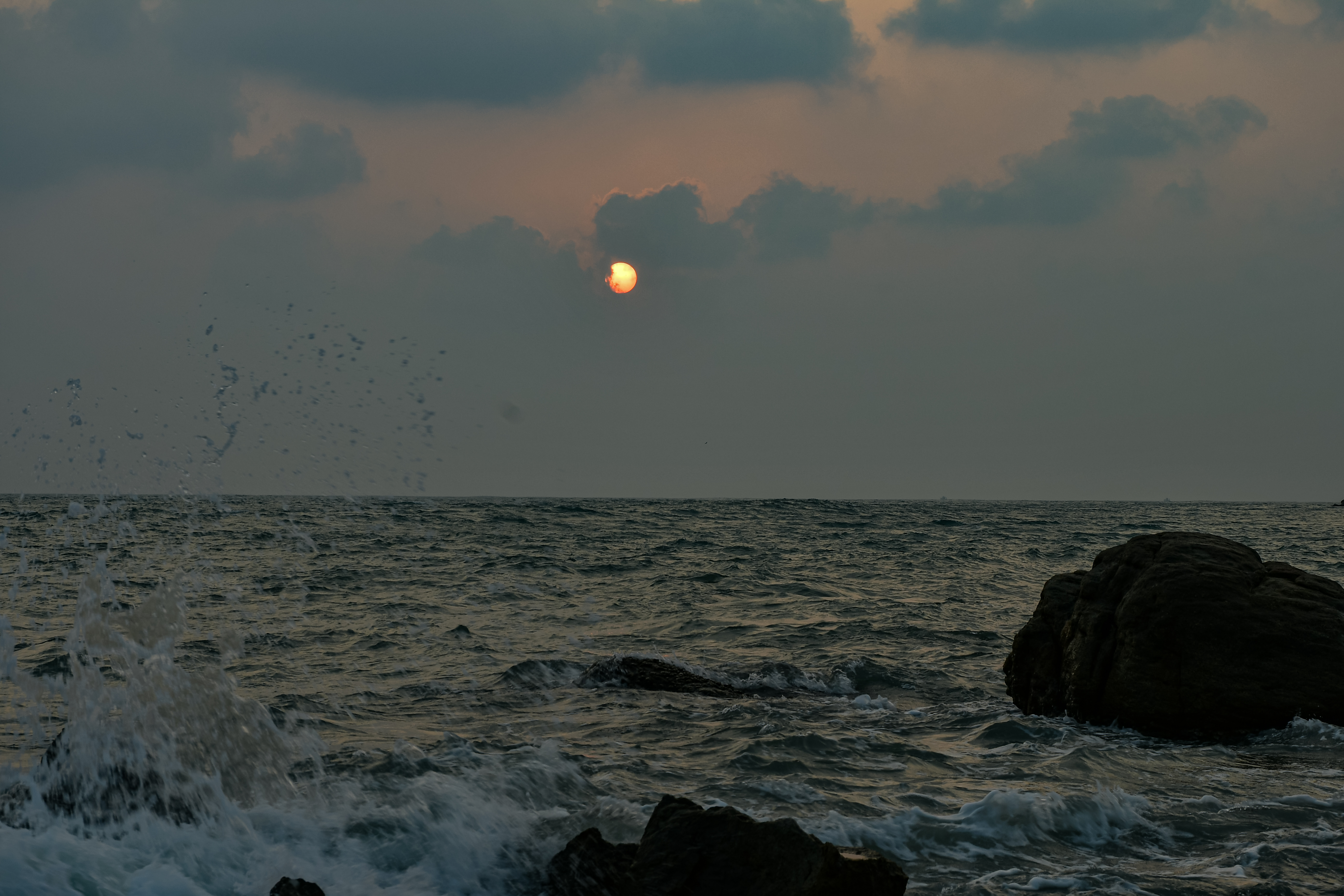 Moody Sunset Over Kanyakumari Sea with Rocks and Waves